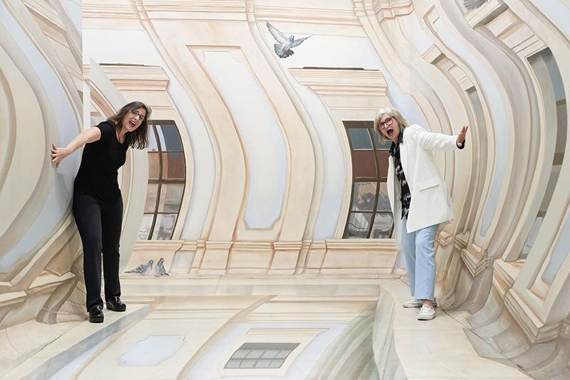 Two women post for the camera in an exhibit at the TiLT Museum at American Dream in East Rutherford, New Jersey.